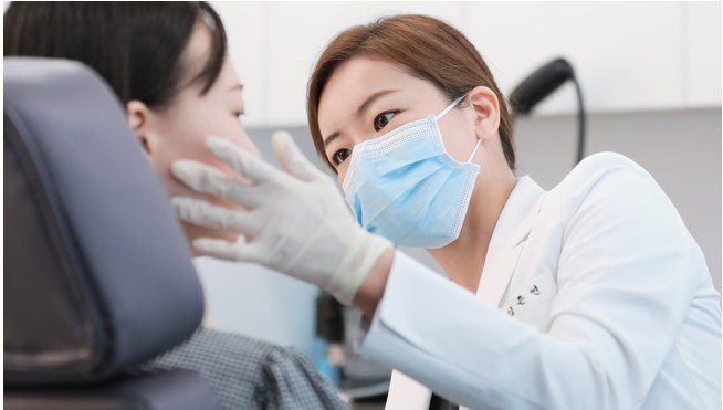 의사가 환자의 눈가를 보며 진료하는 모습